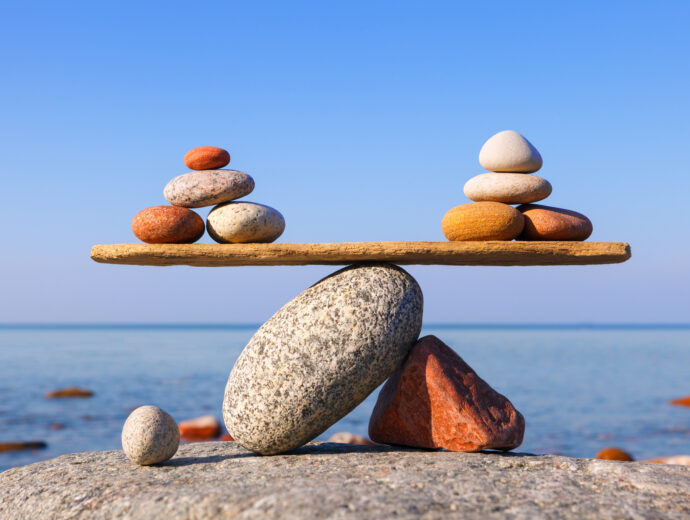 Symbolic scale of the stones on sea background. Concept of harmony and balance. work-life, emotional balance